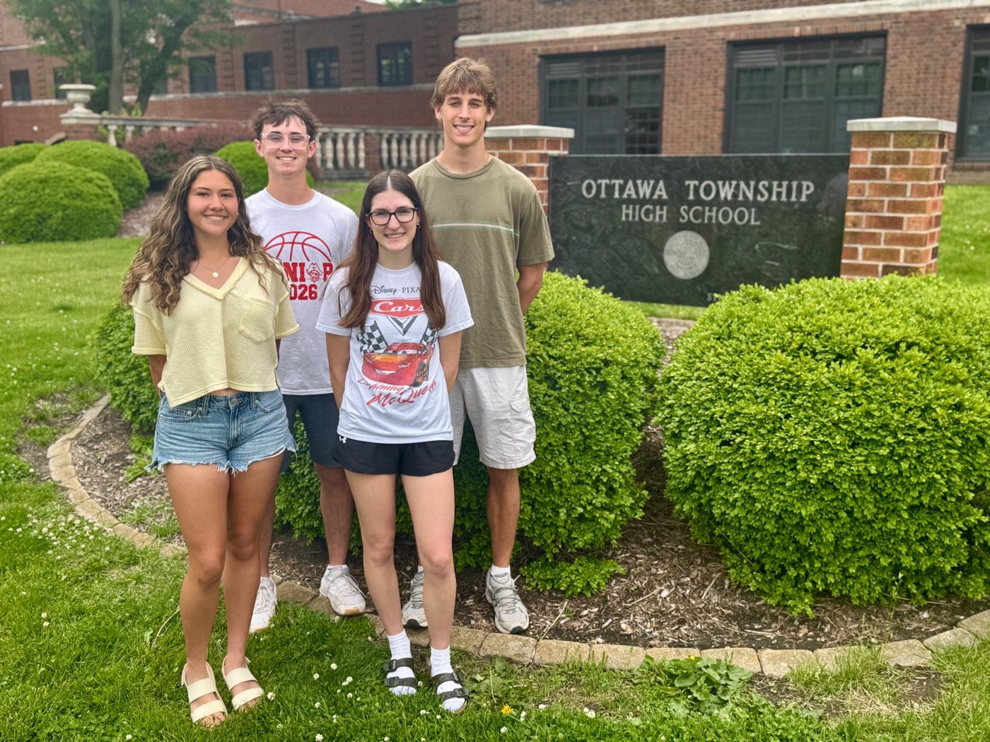 The four 2026 scholarship recipients standing in front of the Ottawa Township High School sign