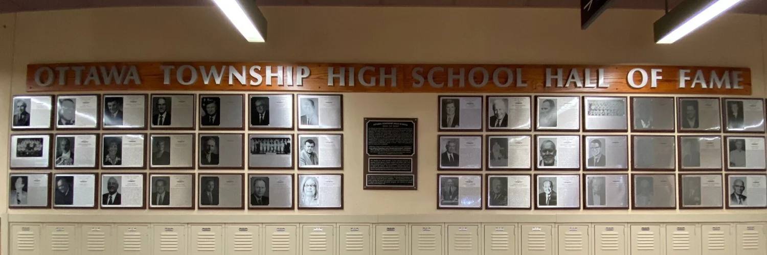 The Ottawa Township High School Hall of Fame wall: rows of framed inductee plaques beneath a wooden sign